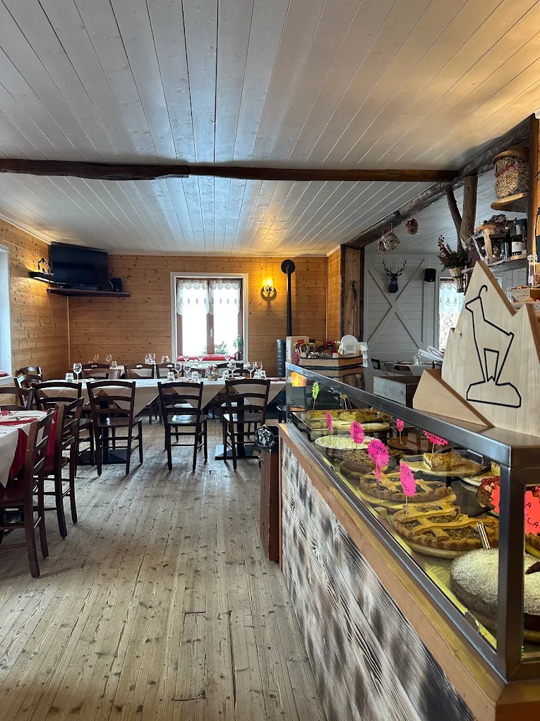 Il banco del bar in legno, con le lampade a gabbia e le bottiglie sugli scaffali